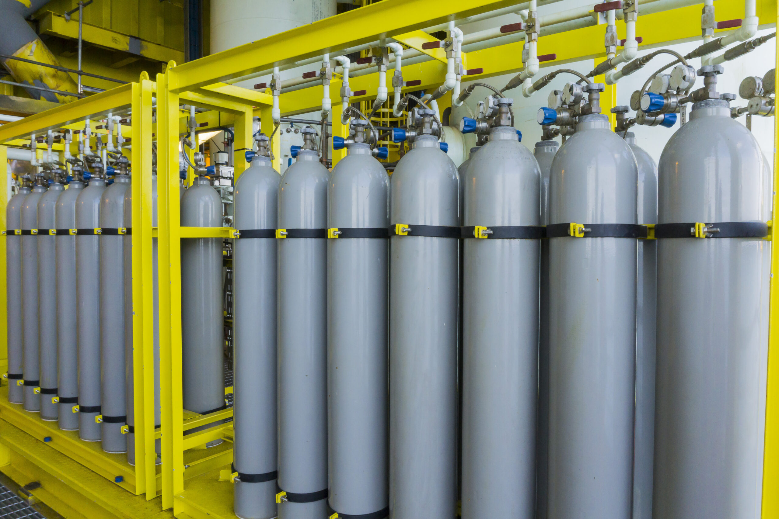 A,Bundle,Of,Grey,Gas,Cylinders,Secured,On,Yellow,Skids